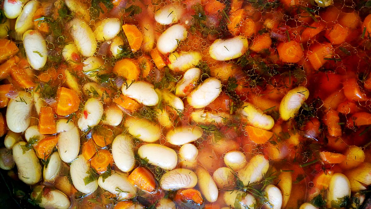 A baking dish that contains giant beans before baking.