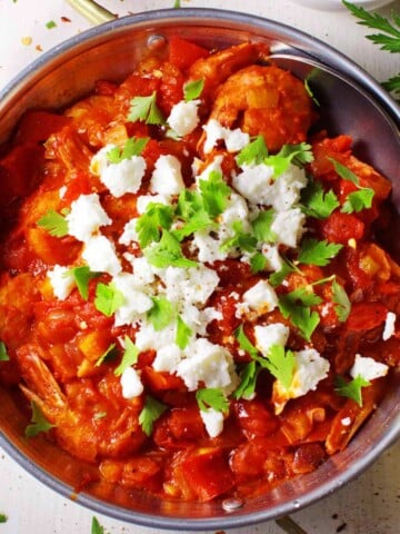 An overhead shot of a traditional Greek pan with shrimp saganaki.