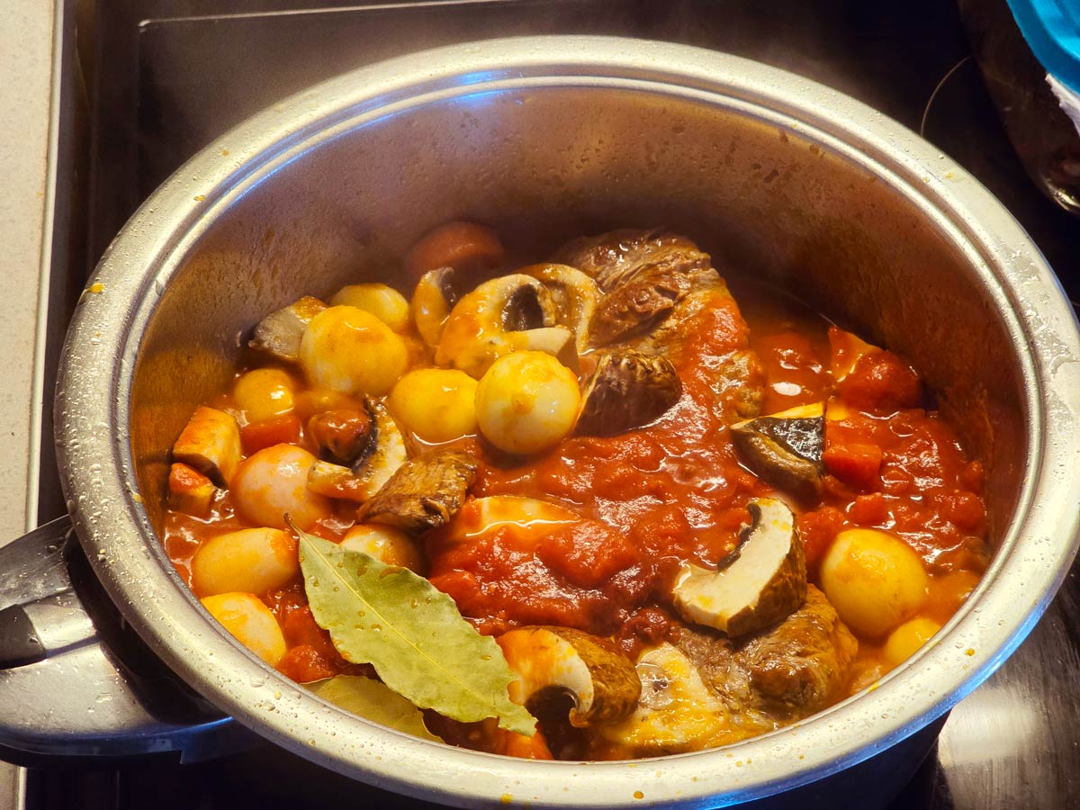 A pot with vegetables for making Greek braised beef shanks.