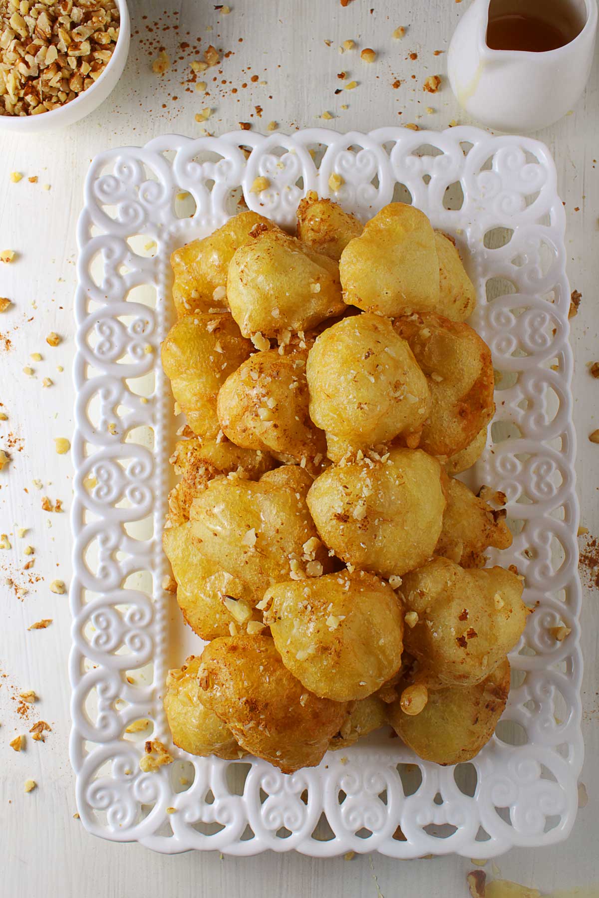 An on-top photo of a white platter with a Greek donut (loukoumades) piles.