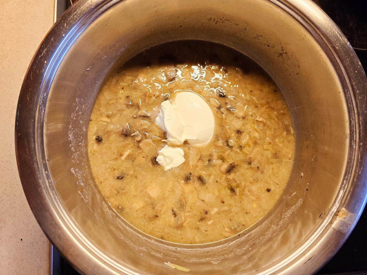 A big pot with Mediterranean mushroom and leek soup topped with cream cheese.