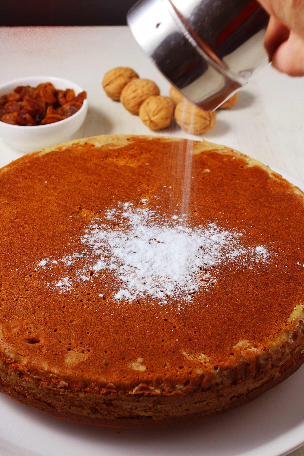 Powdered sugar is dusted over a Greek vegan cake.