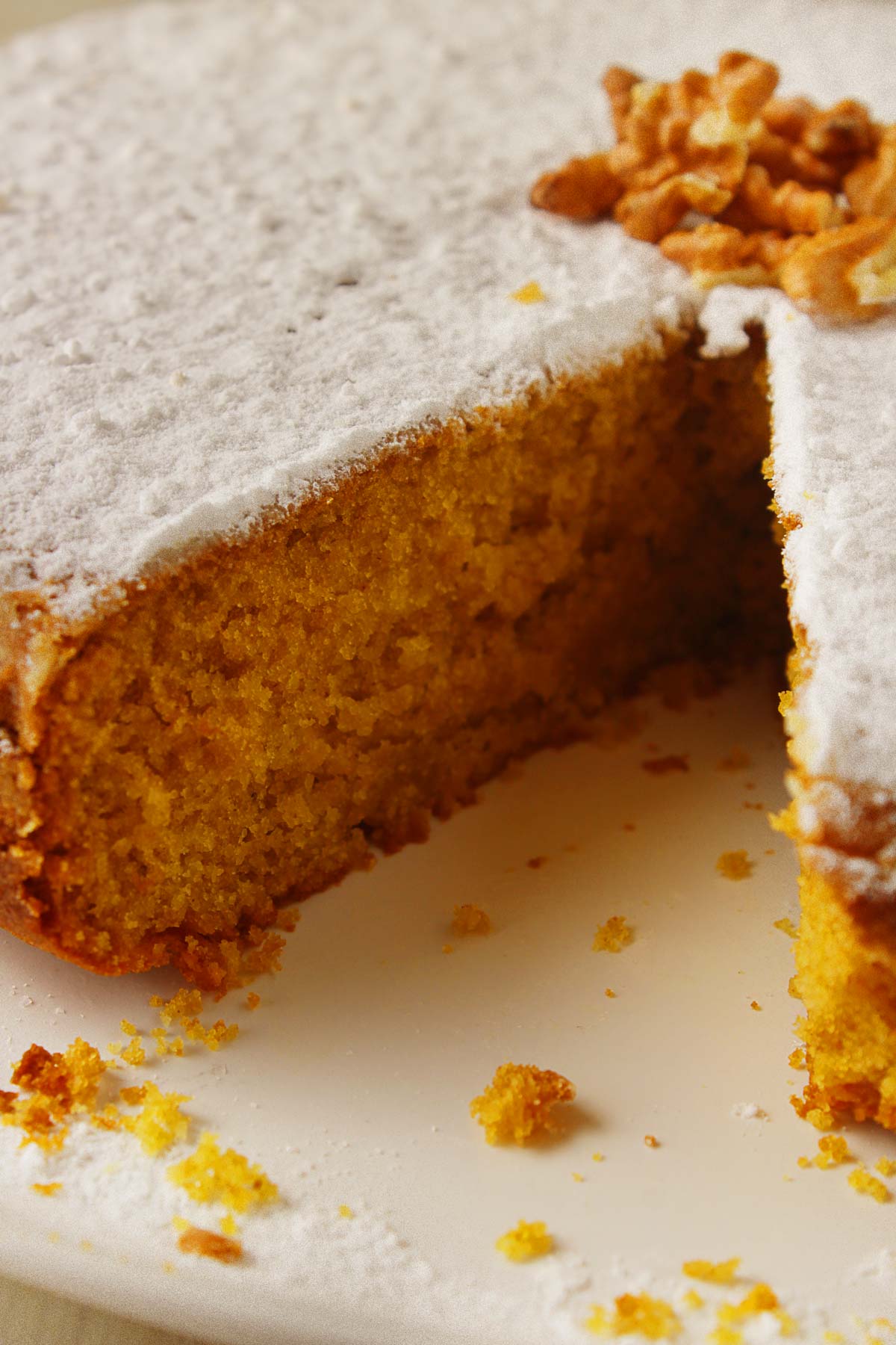 A Greek vegan cake (fanouropita) on a white platter missing on piece.