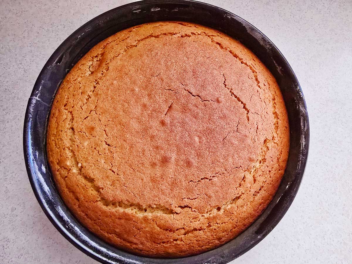 A fresh-baked Greek fanouropita in a black round baking pan.